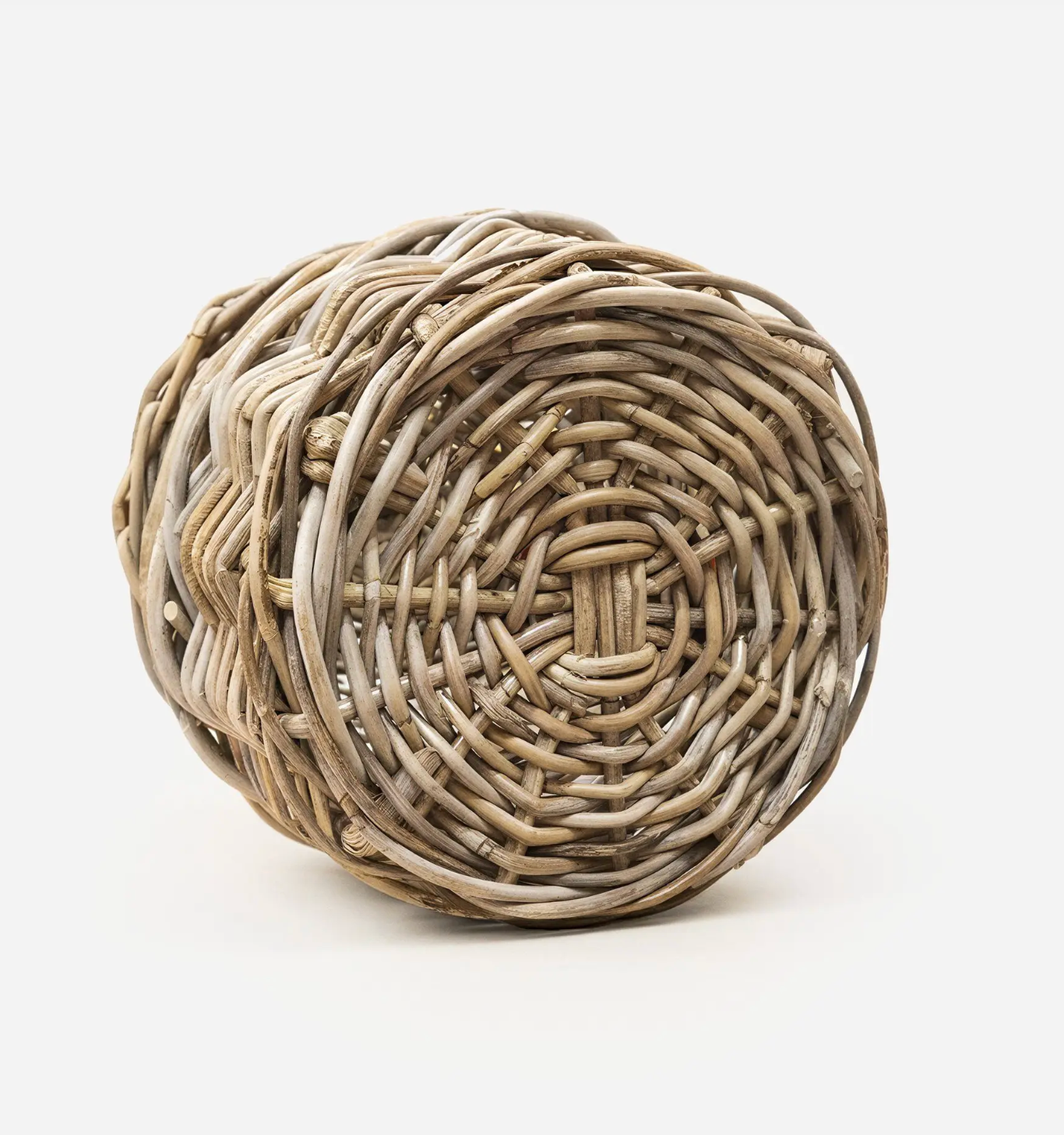 A round woven basket made from natural driftwood or reed-like material, photographed on a clean white studio background.