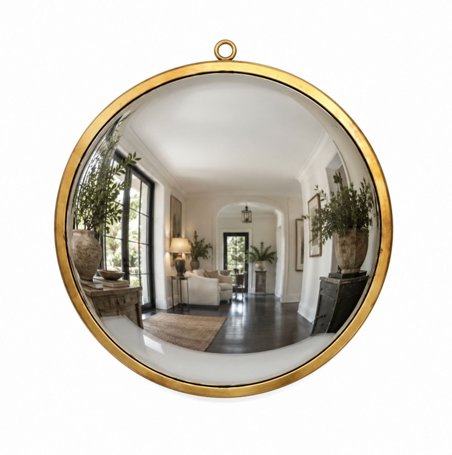 Round wall mirror with a polished gold brass frame and a hanging loop at the top, reflecting a bright, modern living room interior.