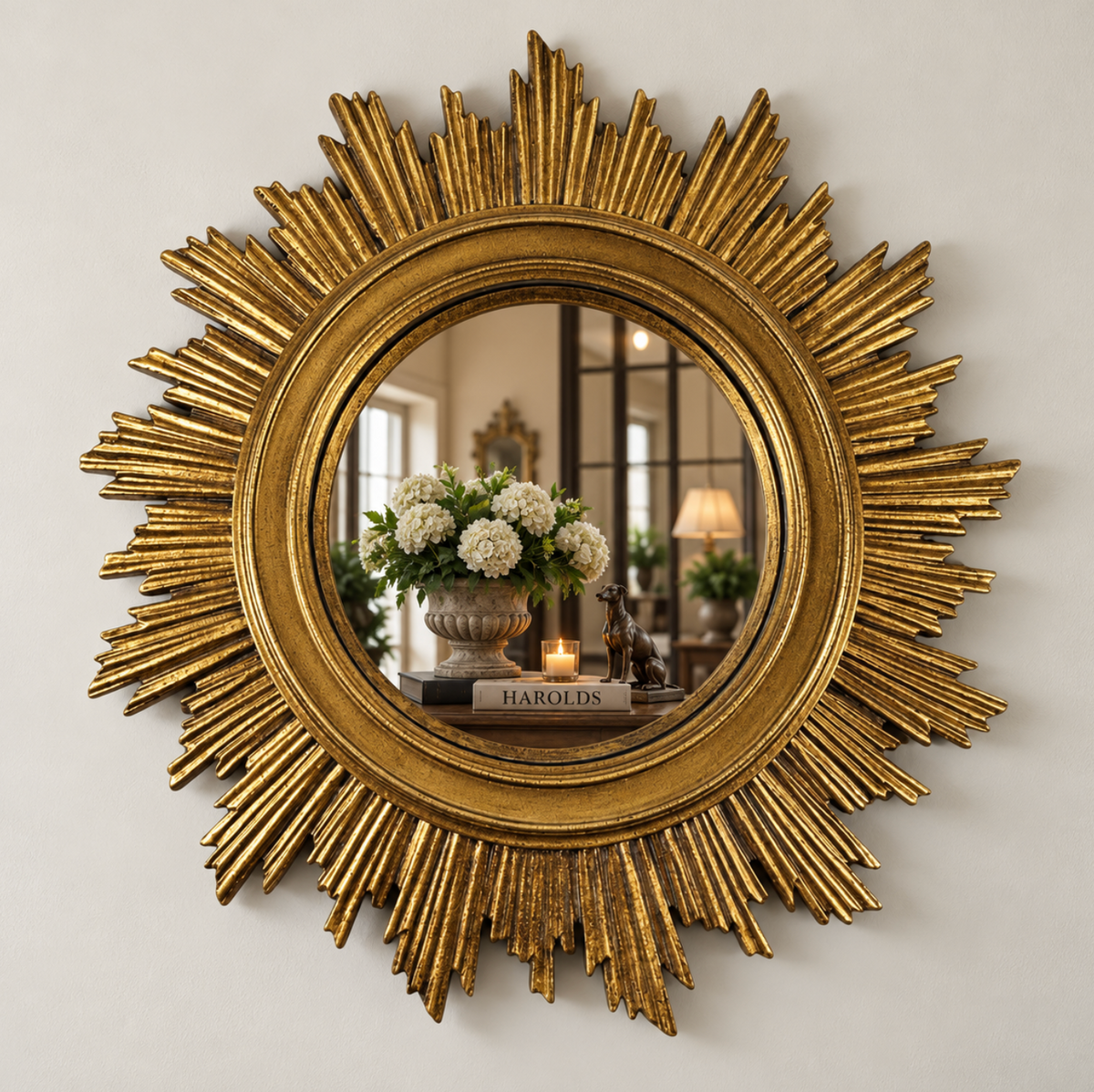 Large gold sunburst mirror with radiating rays and a round central mirror