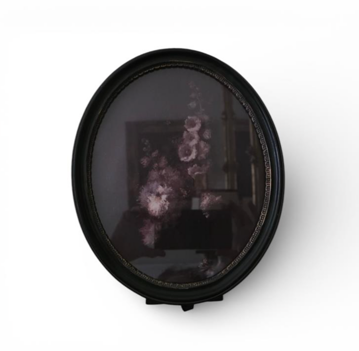 Oval black frame displaying a dark floral image with pink and mauve flowers