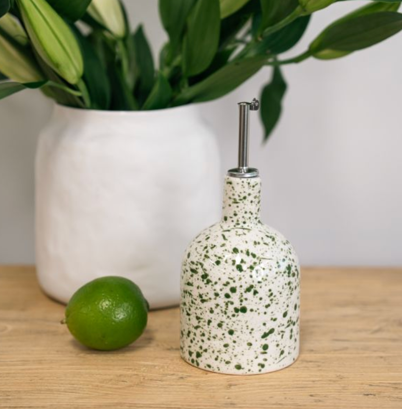Rounded white bottle with green splatter and metal pouring spout