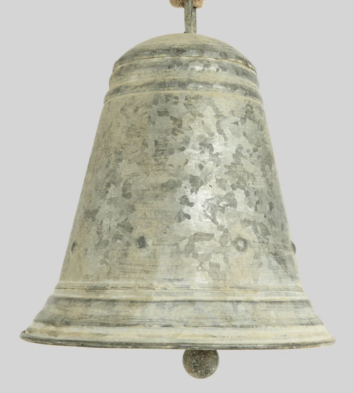 Close-up of flared zinc bell showing raised bands, mottled surface and clapper