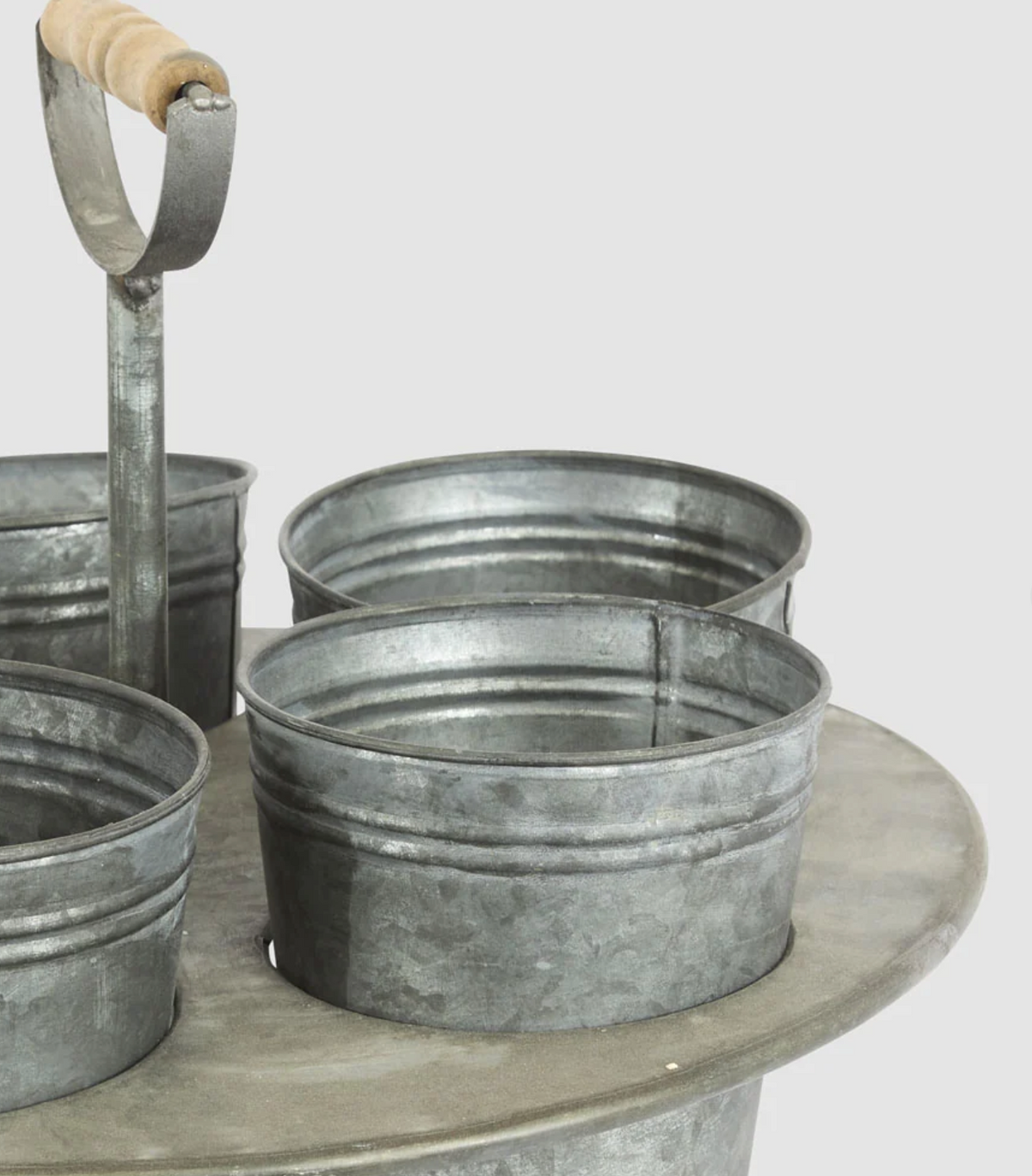 Zinc seedling holder with one pot removed beside the circular stand