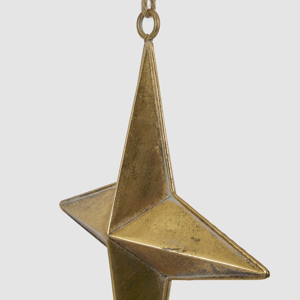 Large gold metal star hanging decoration close-up showing its textured gold finish and raised centre