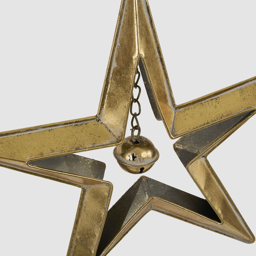 Large gold star with bell hanging decoration close-up showing the small round bell suspended inside the star