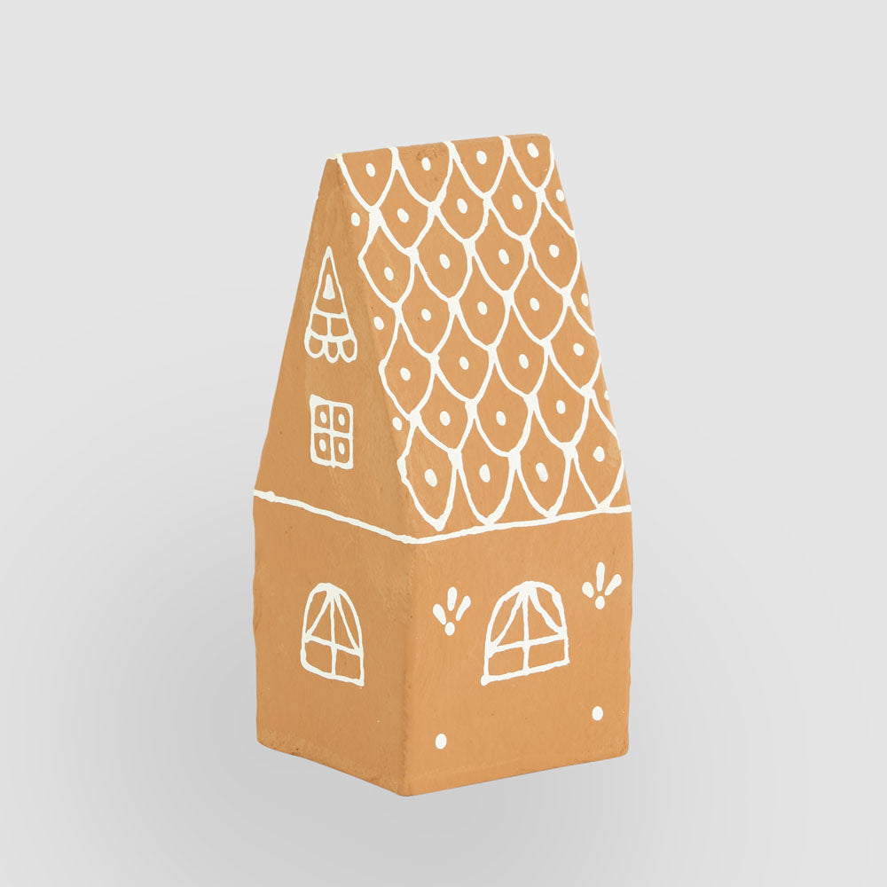 Rear view of the pitched-roof gingerbread house with white painted windows and dotted roof pattern