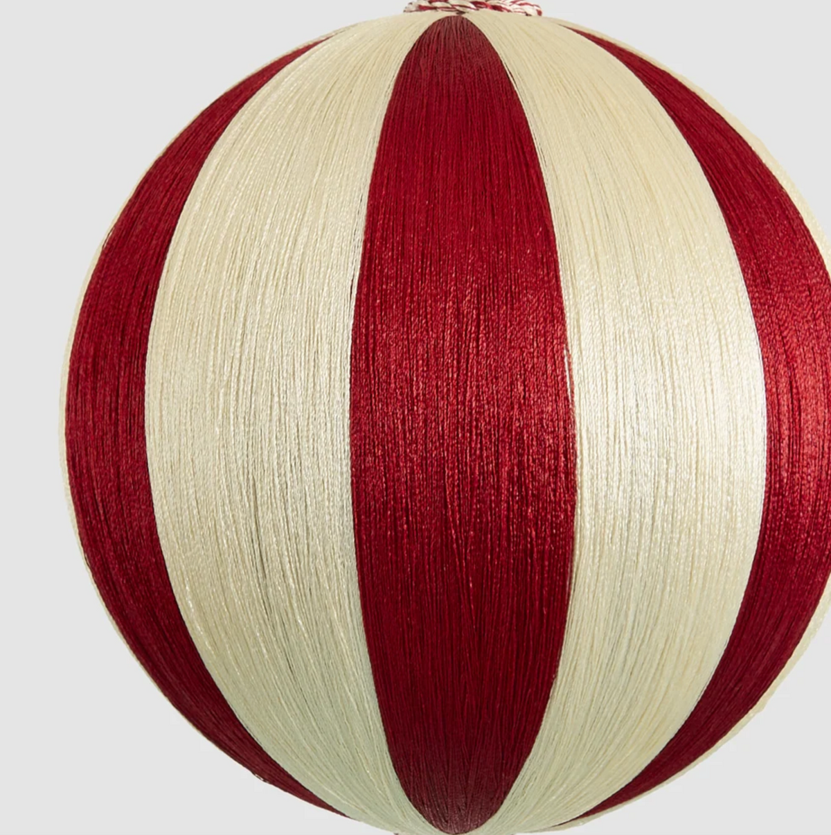 Close-up of the large bauble showing red and ivory stripes and thread texture