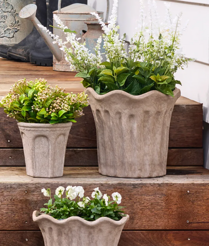 Sand fluted terracotta planters in different sizes with flowers
