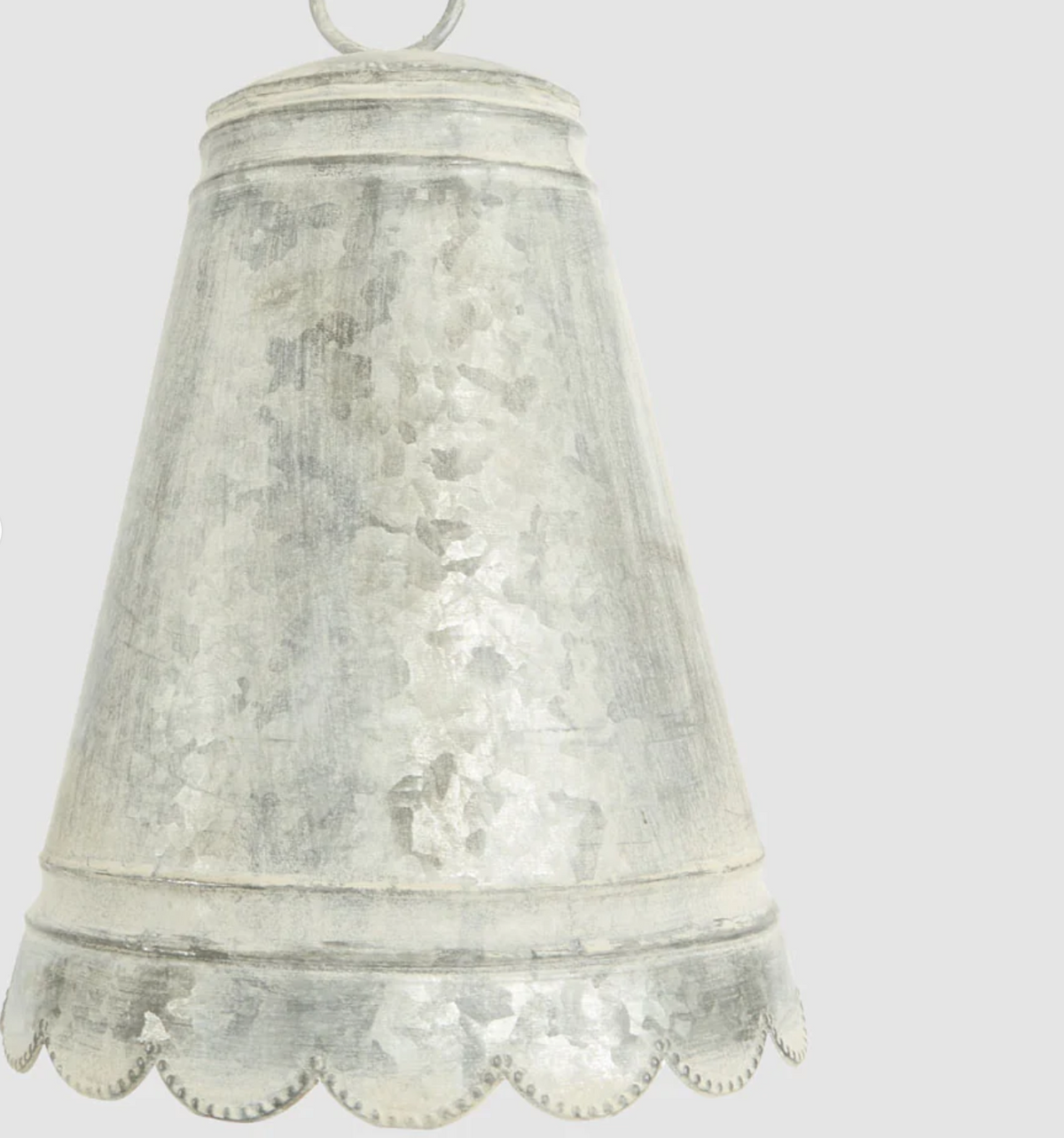 Close-up of large zinc bell showing scalloped edge and weathered finish