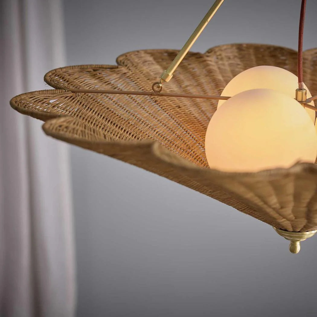 Close-up of scalloped rattan pendant with frosted glass diffusers and antique brass frame