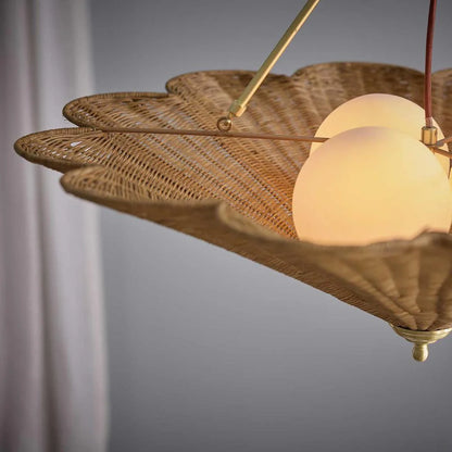 Close-up of scalloped rattan pendant with frosted glass diffusers and antique brass frame
