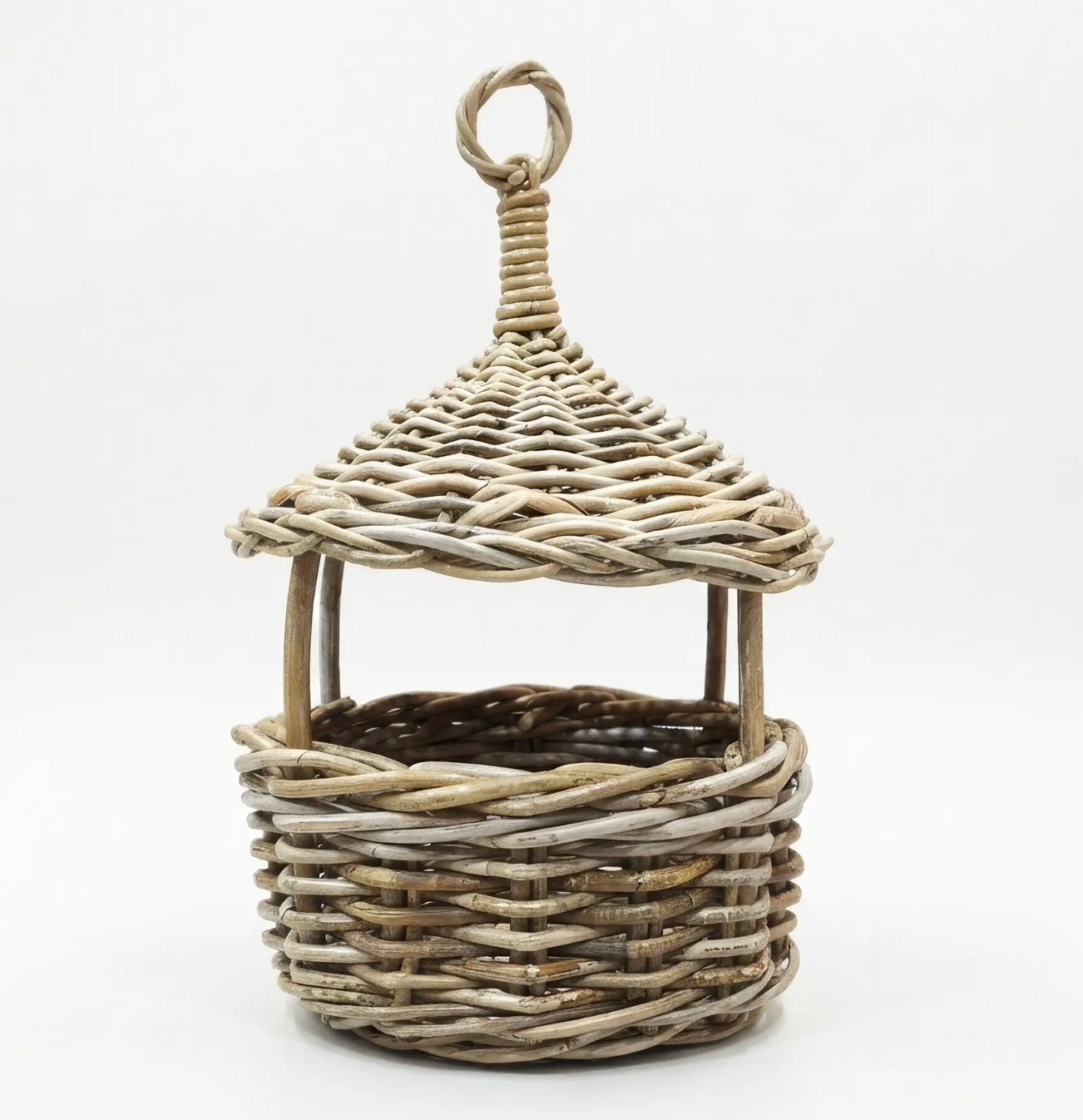 A small decorative wicker basket with a pointed roof and hanging loop, shown on a plain white studio background.