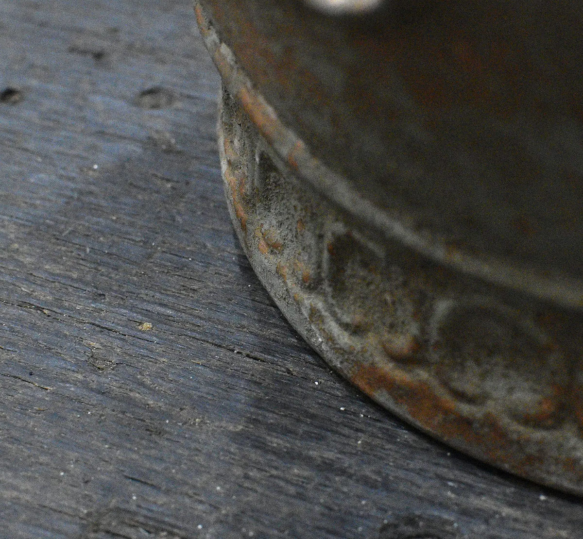 Close detail of embossed scrollwork band and aged patina on metal crown dish base