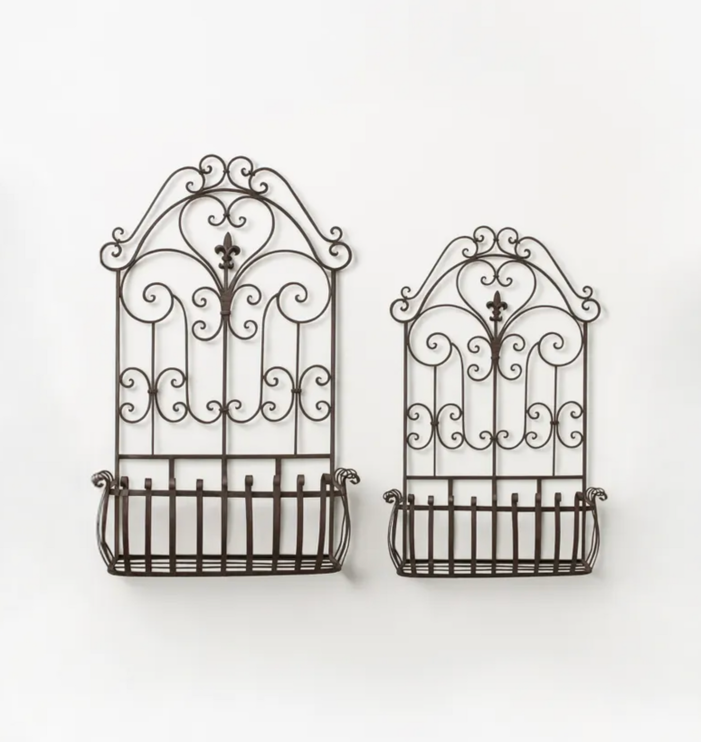 Two dark brown wrought iron wall-mounted baskets with decorative scrollwork tops, shown against a plain white background.