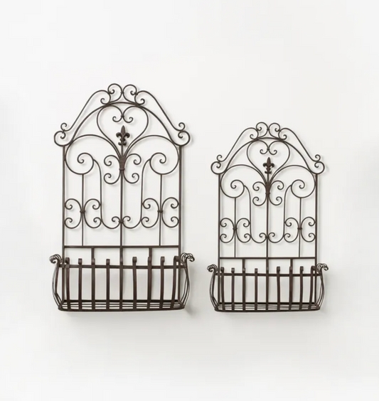 Two dark brown wrought iron wall-mounted baskets with decorative scrollwork tops, shown against a plain white background.