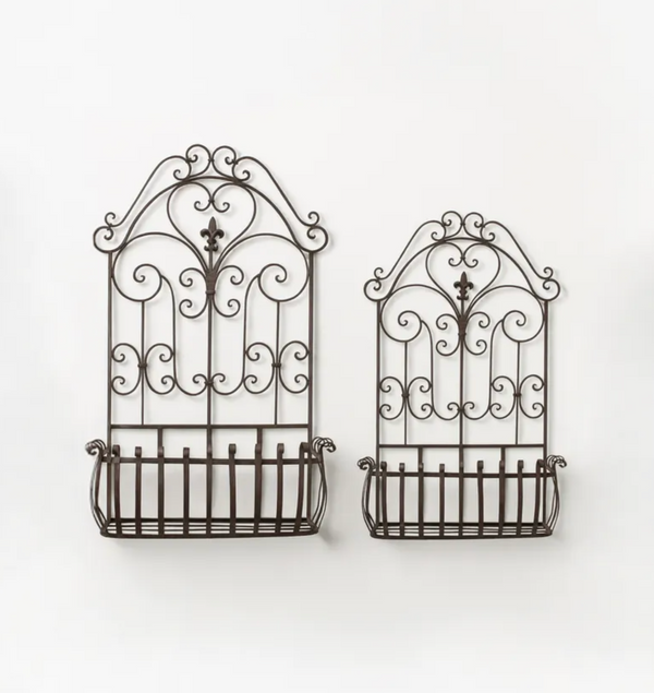 Two dark brown wrought iron wall-mounted baskets with decorative scrollwork tops, shown against a plain white background.
