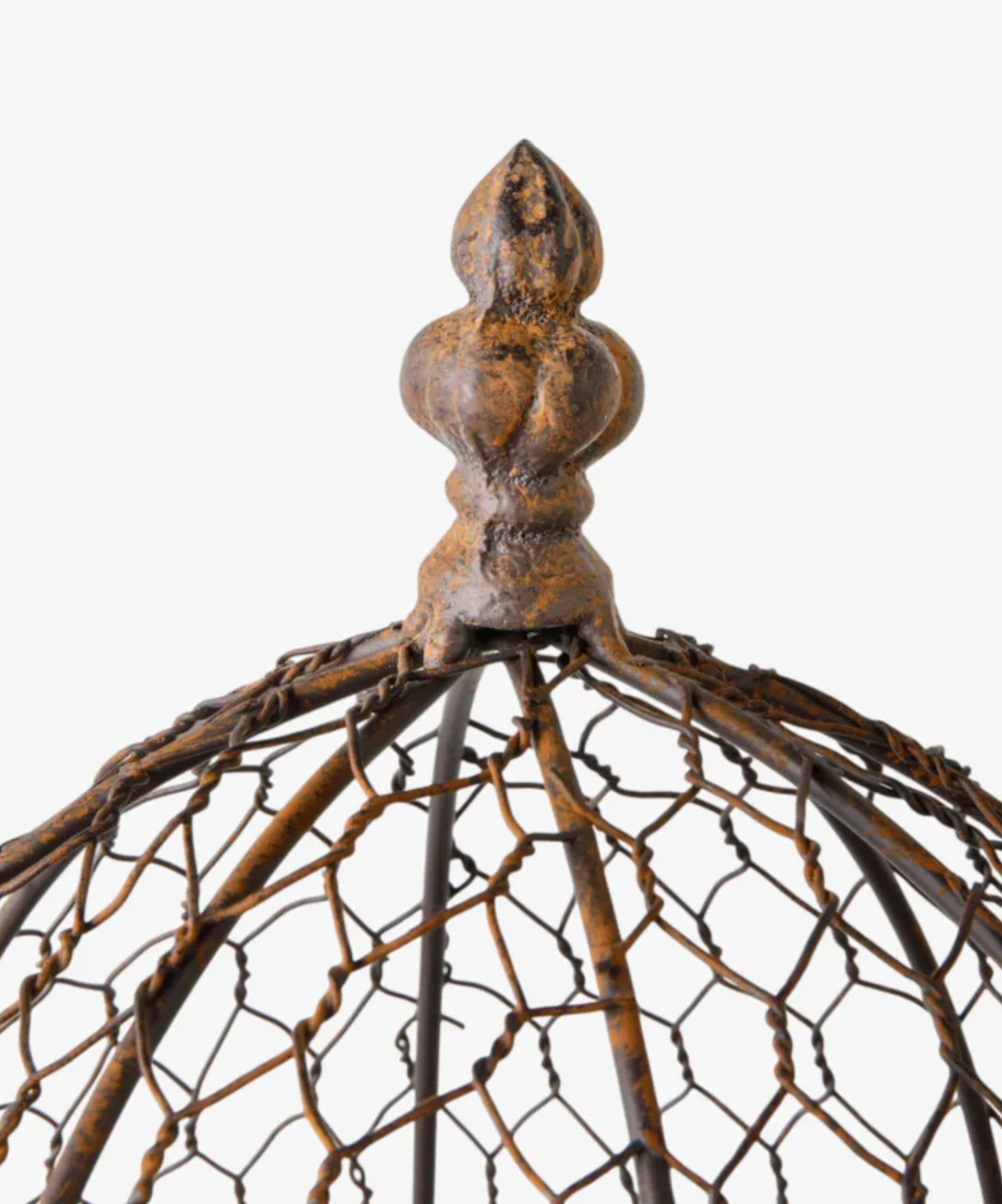 Close-up of a rustic metal birdcage top featuring a textured, weathered bronze finial and a woven wire dome structure on a plain white background.