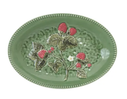 An oval green ceramic plate featuring a raised relief design of a strawberry plant with red berries and green leaves, set against a plain white background.