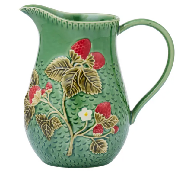 A green ceramic pitcher decorated with embossed berries, leaves, and small white flowers, shown on a plain white background.