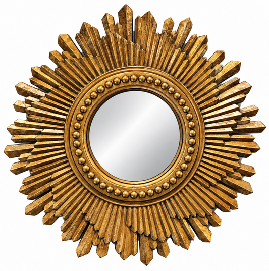 A round decorative wall mirror with a sunburst frame in a distressed gold finish, featuring radiating rays and a beaded inner border.
