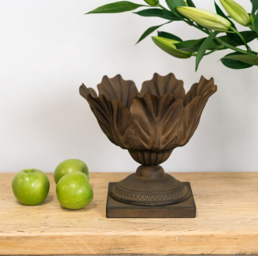 Bronze rust-coloured acanthus leaf bowl on a square pedestal base beside three green apples