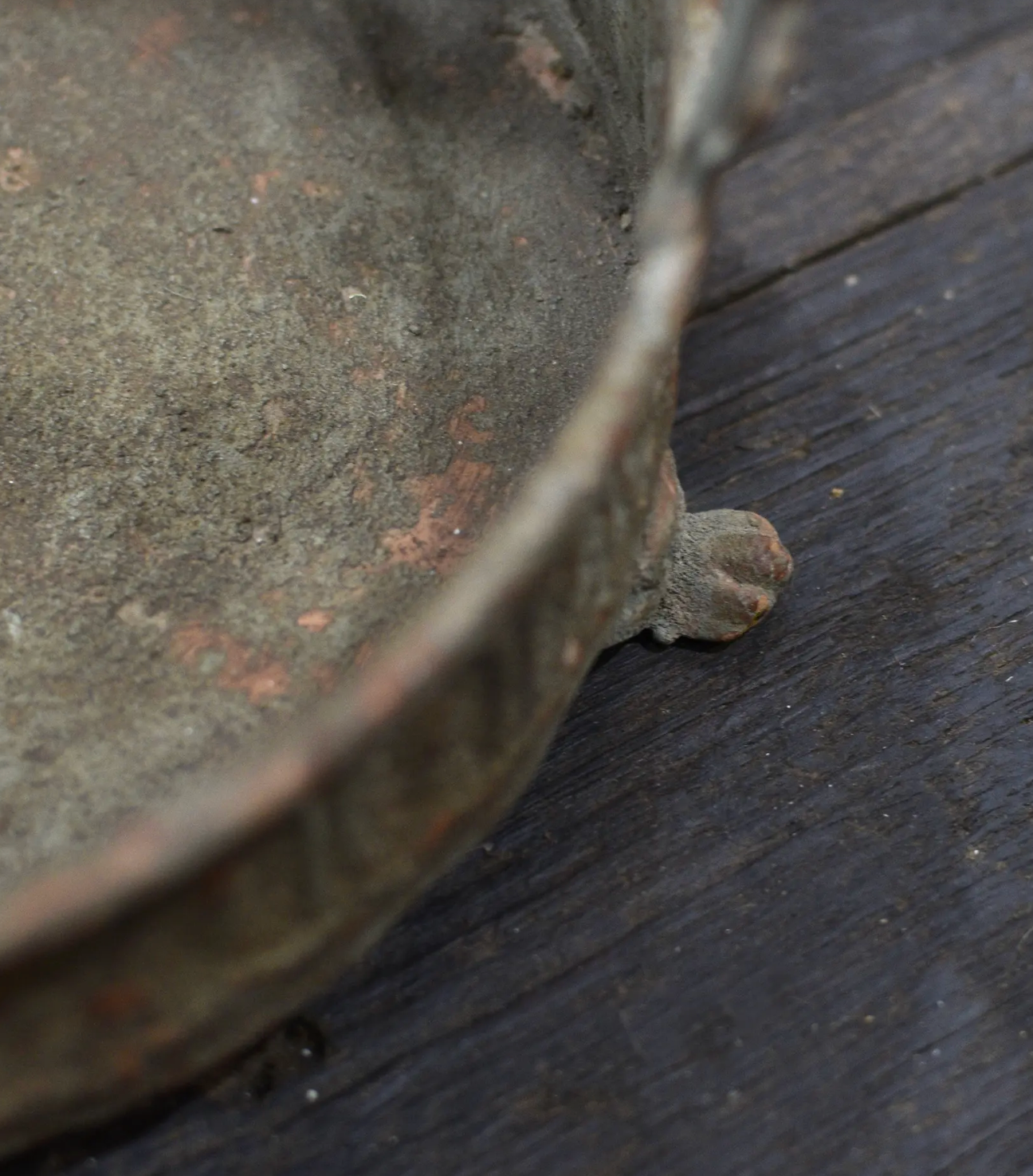 Close detail of footed base of the Avilia Bird Planter showing aged patina and embossed rim