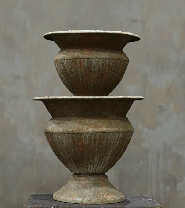 Two fluted urns in Oxido finish stacked showing Medium and Large size comparison with dark weathered patina