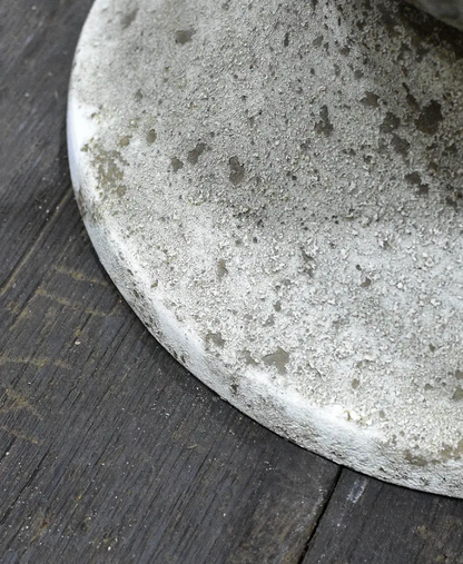 Close detail of pitted stone-like base texture on fluted urn in aged white patina