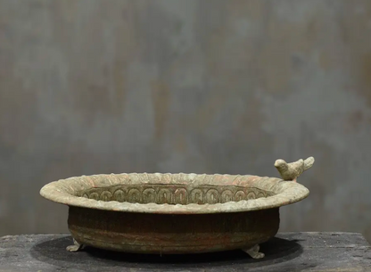Cast iron bird dish in darker aged patina showing perched bird and scalloped rim detail