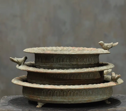 Close detail of scalloped rim and embossed arch band on cast iron bird dish in aged white patina