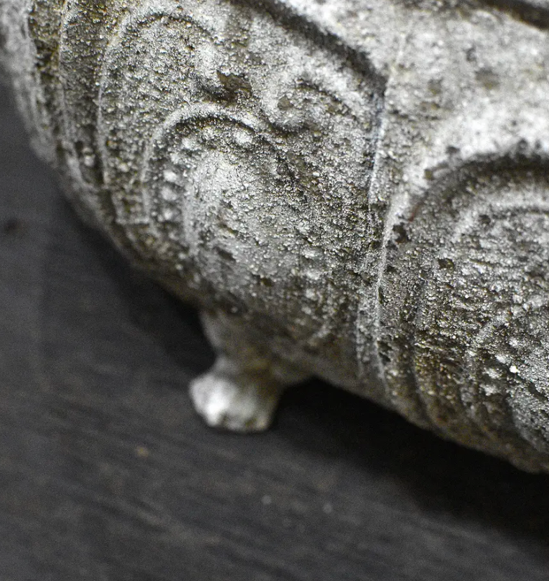 Close detail of beaded rim and embossed panel border on trough planter in aged patina