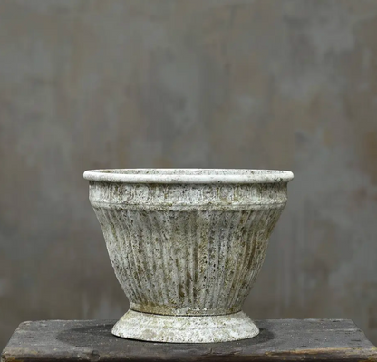 Two fluted metal planters in aged Blanca patina stacked showing Small and Medium size comparison on timber plinth