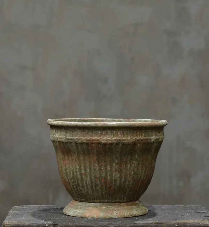 Two fluted metal planters in aged Oxido patina stacked showing Small and Medium size comparison