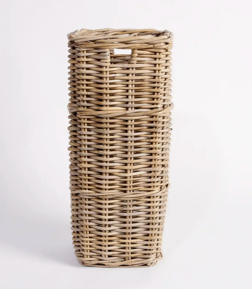 Tall square Kubu cane umbrella stand held by person showing scale - natural woven rattan with cut-out handles