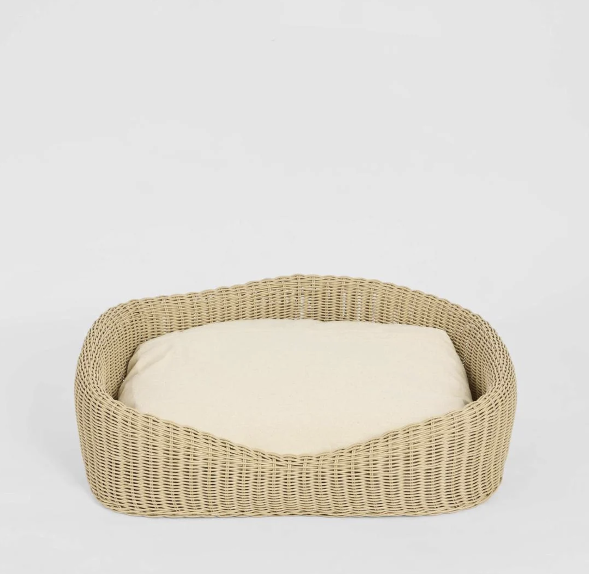 Rattan Pet Bed in natural PE rattan with cream cushion - angled view
