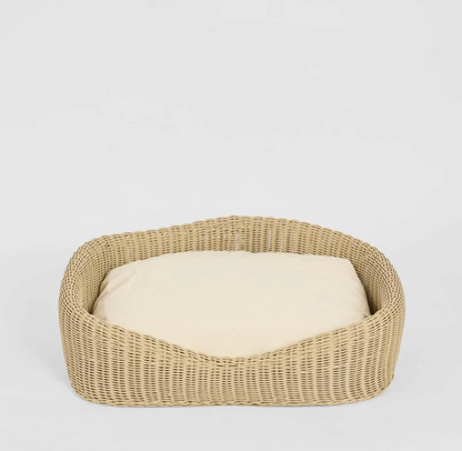 Rattan Pet Bed in natural PE rattan with cream cushion - angled view