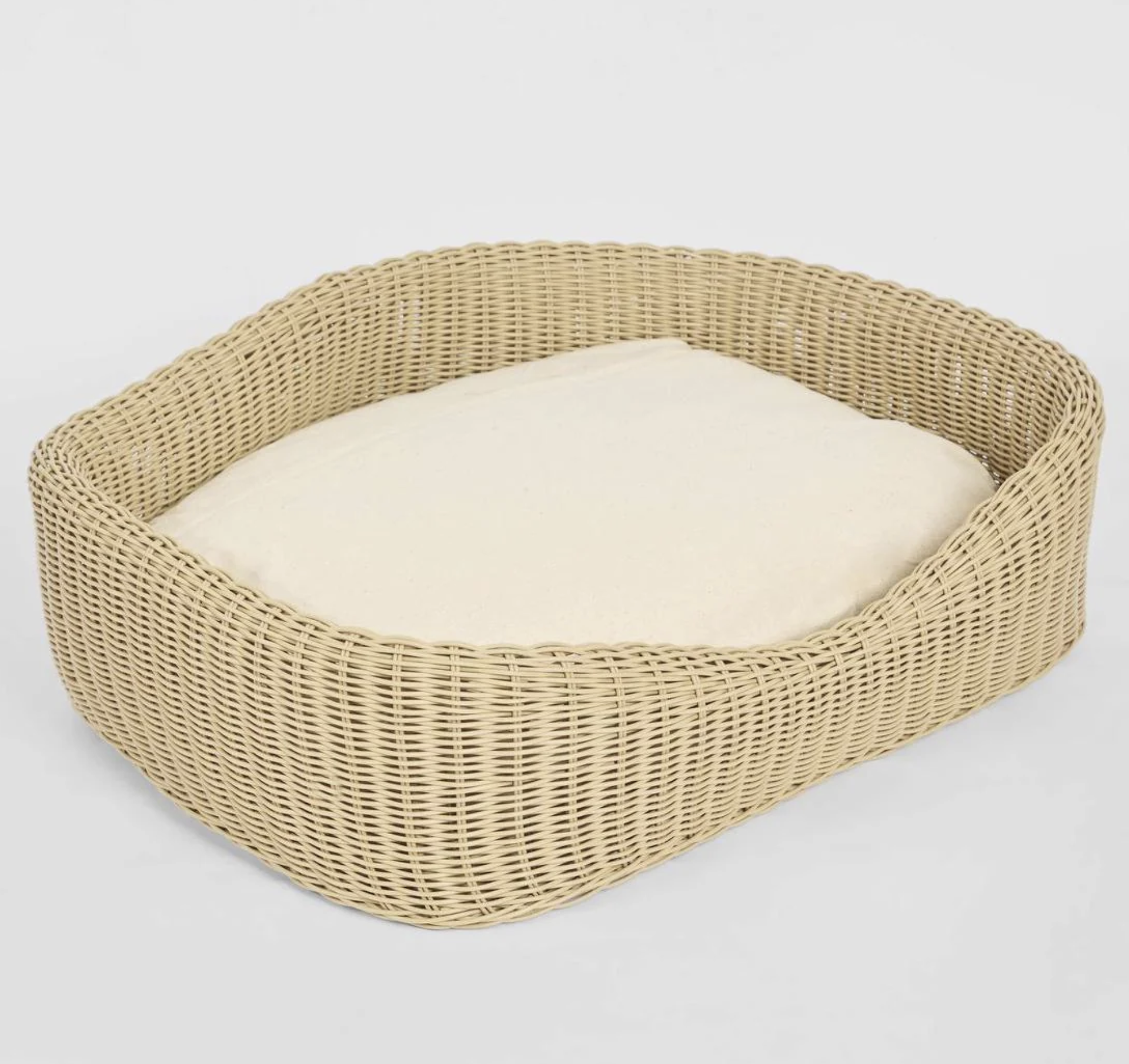 Rattan Pet Bed overhead angle showing open form and cream cushion