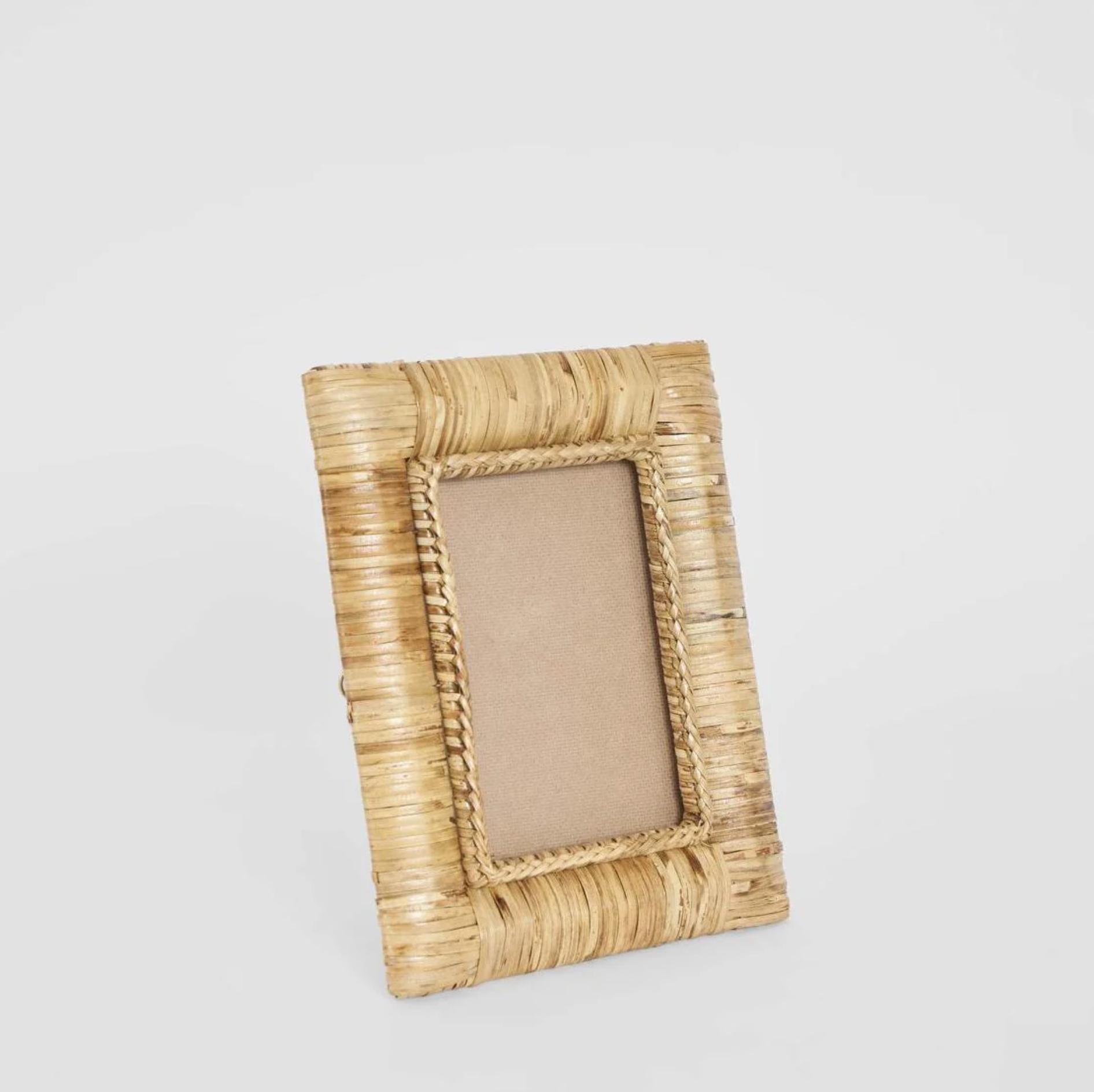 Rattan Photo Frame in natural standing on shelf - angled view