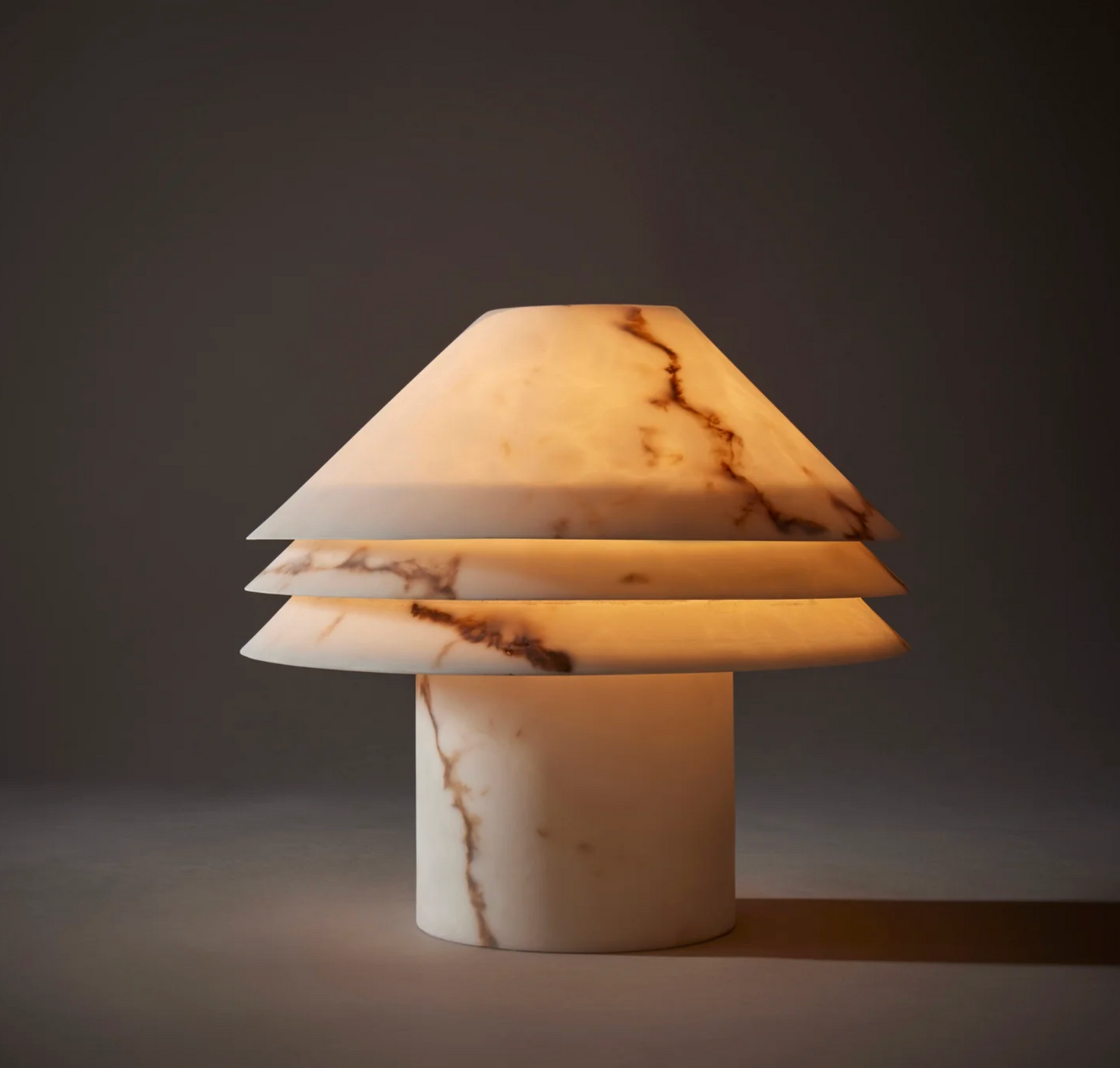 Faux alabaster tiered table lamp unlit, showing ivory tone and natural veining