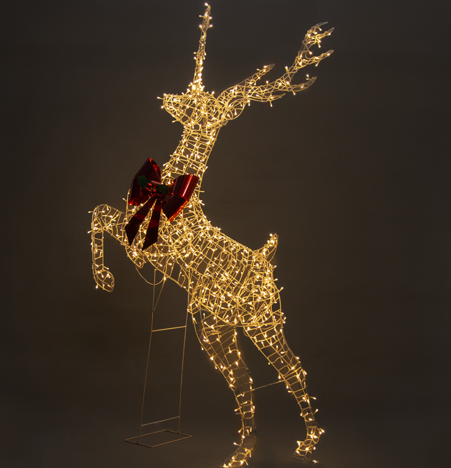 Light-up rearing reindeer with warm white twinkle lights and red bow