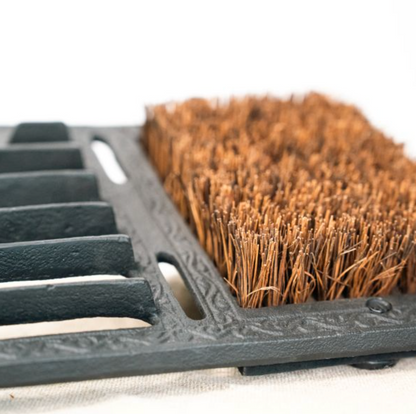 Black boot scraper and brush styled near a doorway