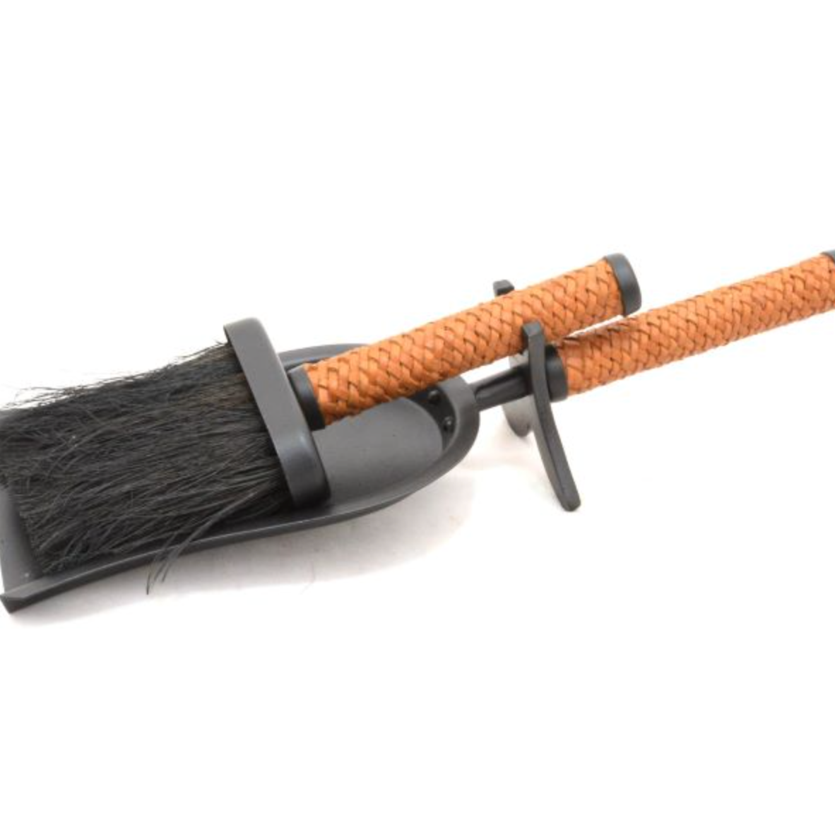 Close-up of fireplace shovel and brush set with leather handles