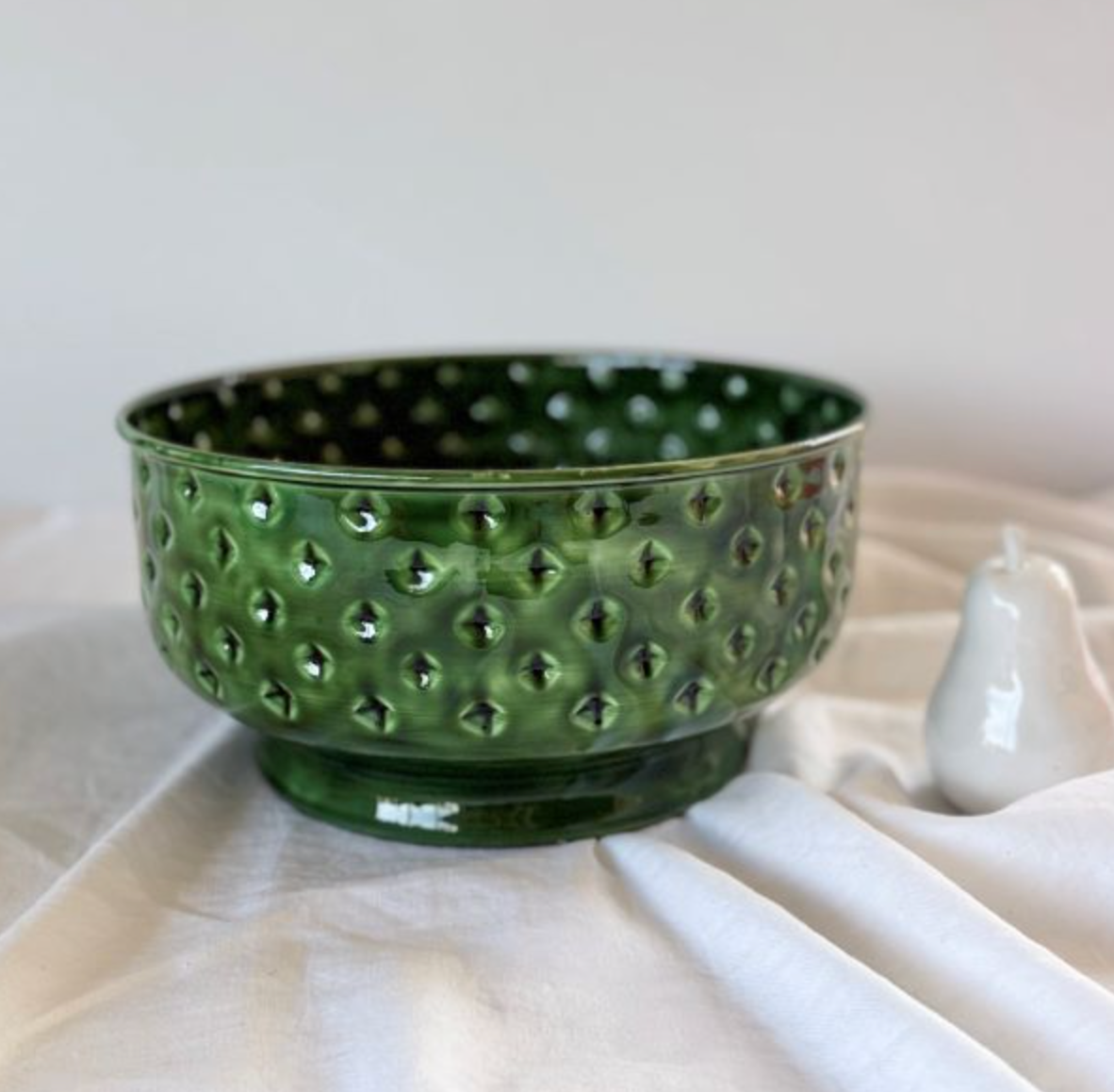 Green enamel spot fruit bowl styled on a table