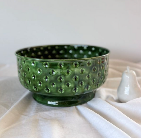 Green enamel spot fruit bowl styled on a table