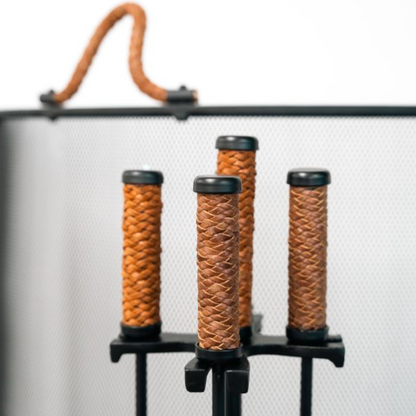 Five-piece fire tool set styled beside a lit fireplace
