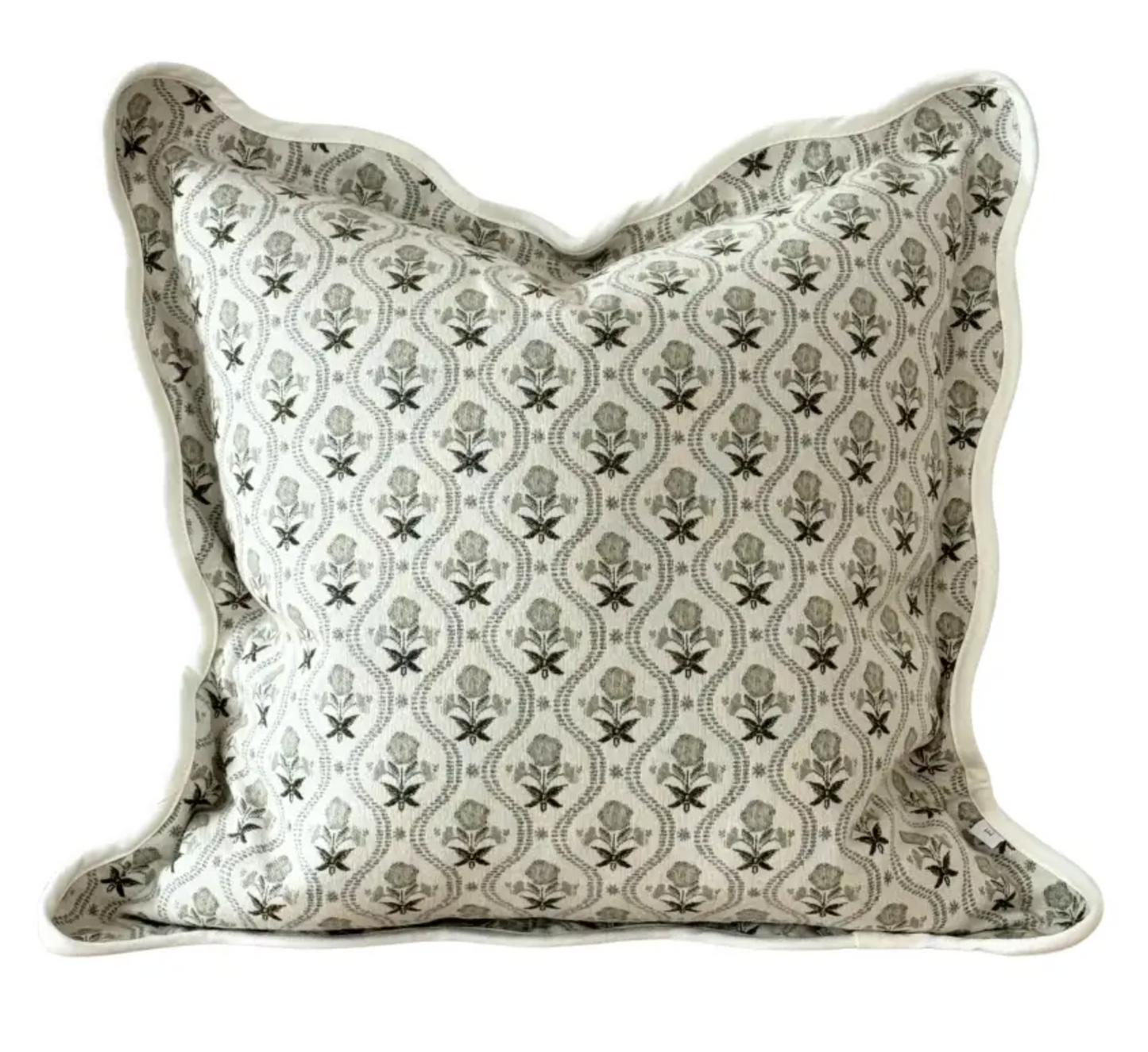 Close-up of sage and cream floral fabric and scalloped edge on a square cushion cover