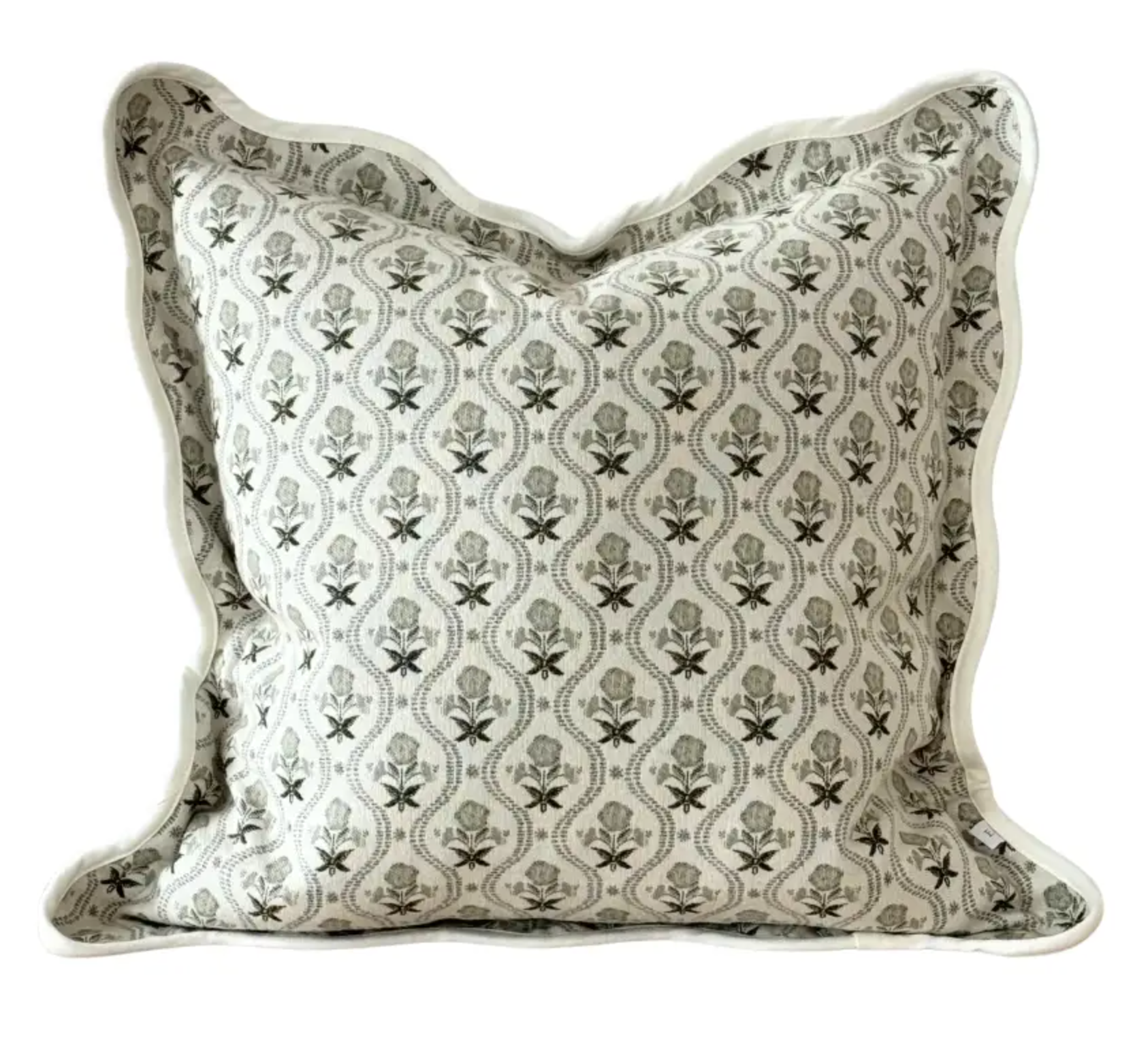 Close-up of sage and cream floral fabric and scalloped edge on a square cushion cover