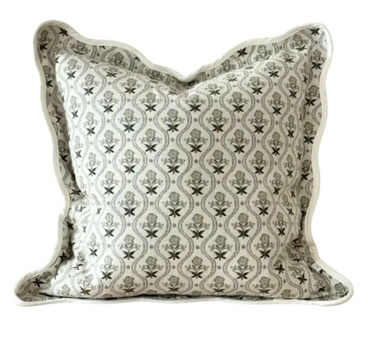 Close-up of sage and cream floral fabric and scalloped edge on a square cushion cover