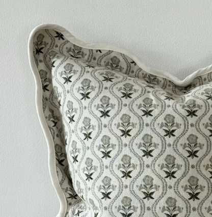 Close-up of sage print fabric and scalloped edge on a square cushion cover