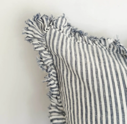 Close-up of blue and cream striped linen fabric and ruffled edge on a cushion